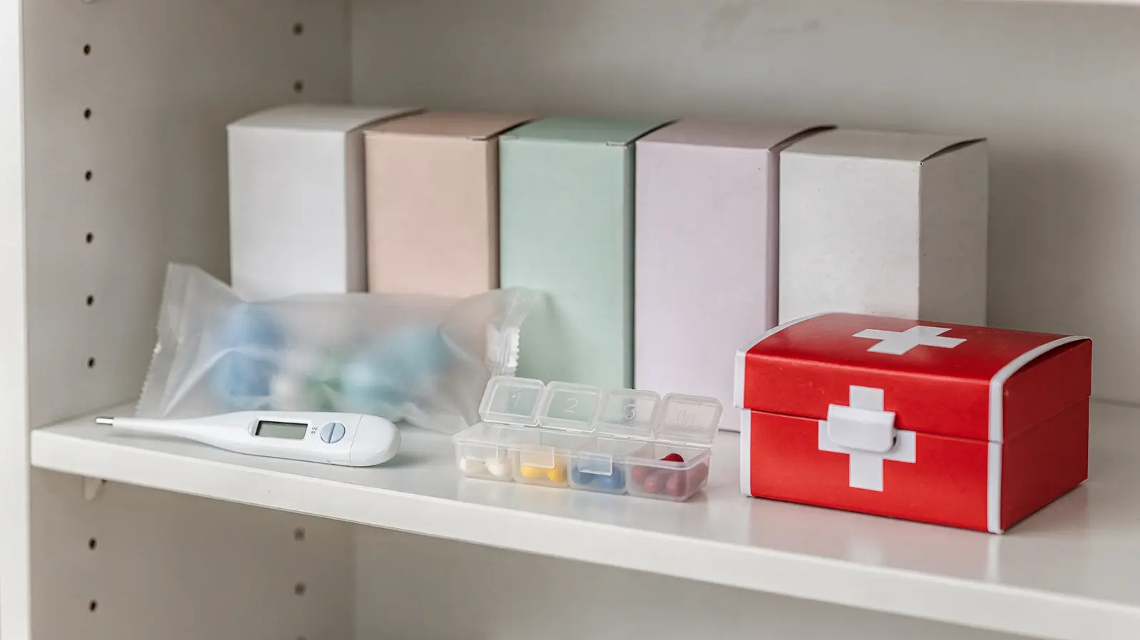 Geordeter Medizinvorrat mit Schmerzmitteln, Thermometer und Verbandskasten für den Notfall